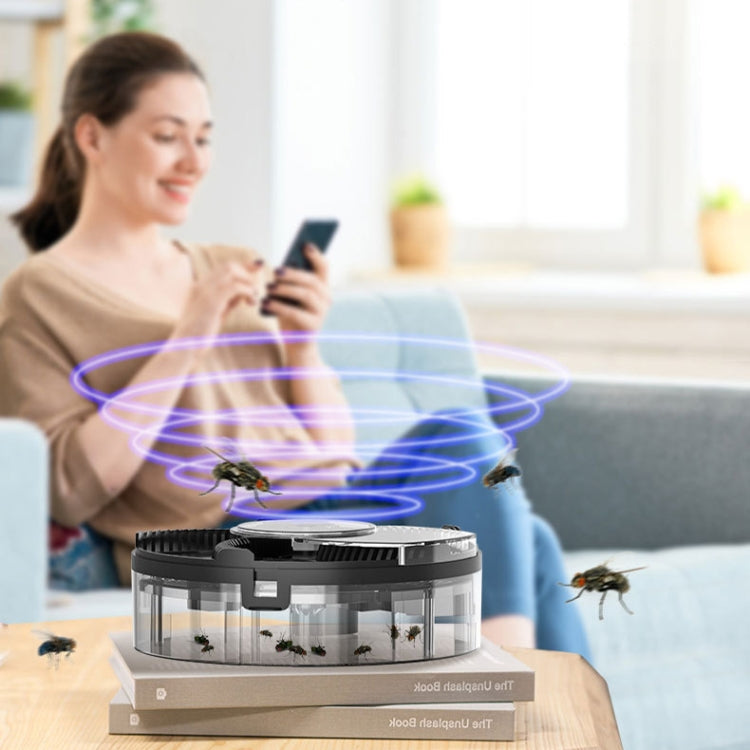 Black automatic fly trap with transparent chamber and visible insect attractor effect.