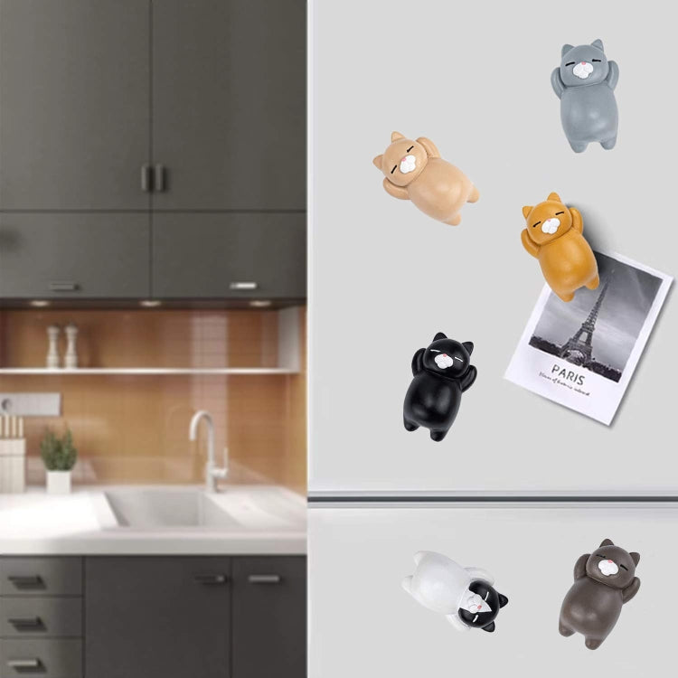Cat resin fridge magnets attached on a refrigerator with small paper photo clips.