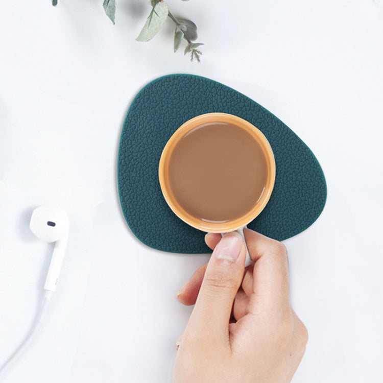 Dark teal teardrop silicone coaster holding a cup on tabletop.