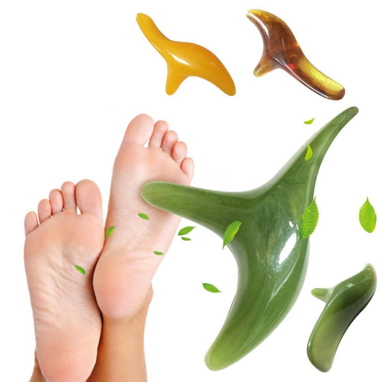 Green sparrow-shaped massage point tool pressed to bare feet, glossy three prongs.