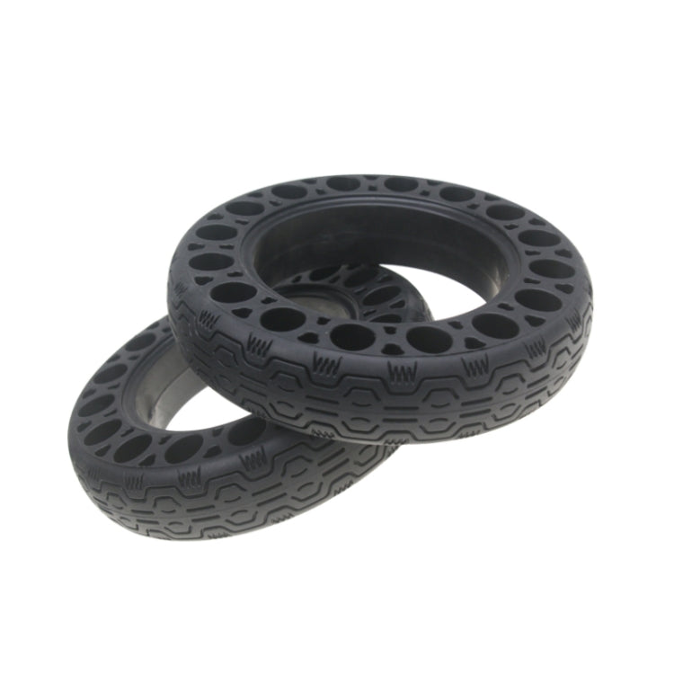 Solid run-flat tire with tread pattern and oval sidewall cutouts in dark rubber
