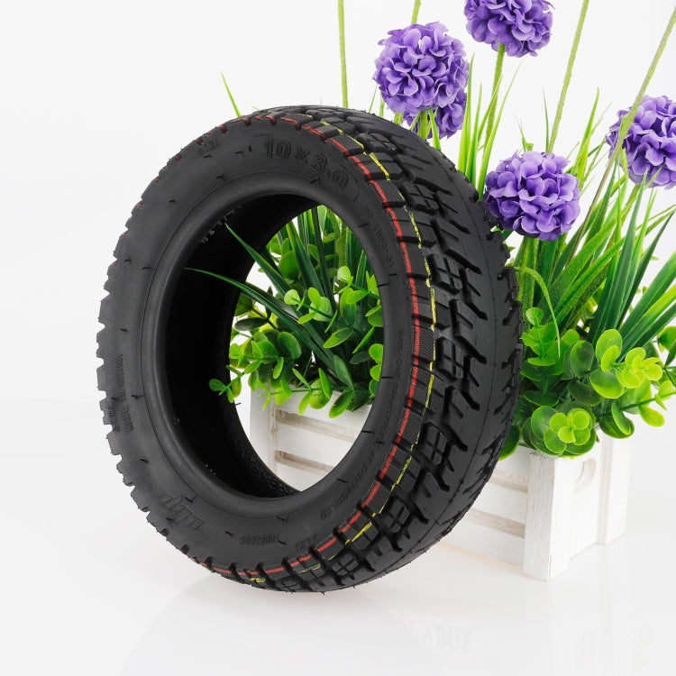 10-inch off-road tubeless tire, black tread with red/yellow sidewall accents