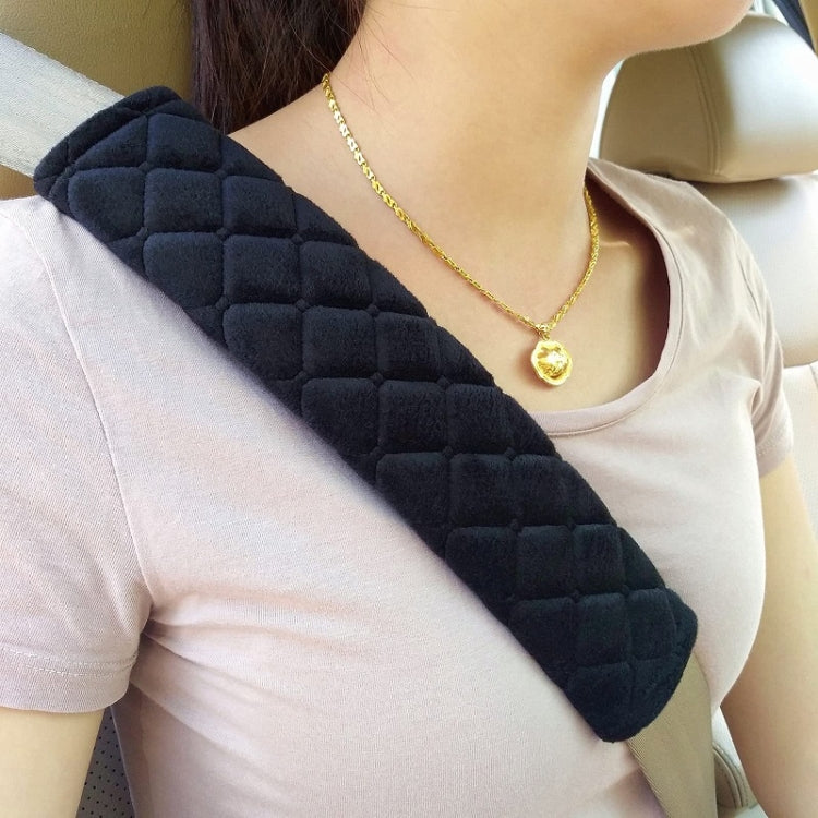 Car seat belt protector pad in dark charcoal plush, close-up on shoulder belt.