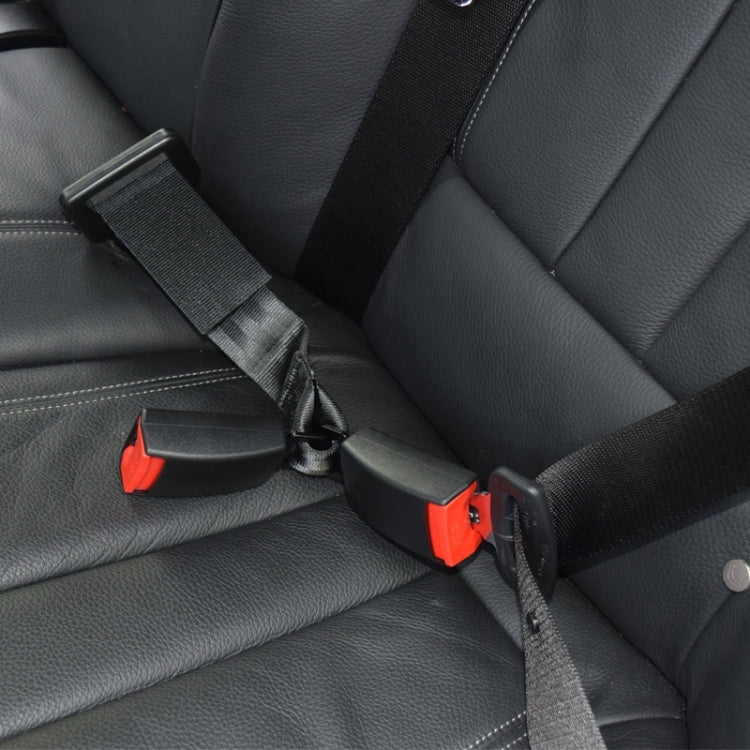 Car seat safety belt connector close-up, black strap with red release and metal buckle