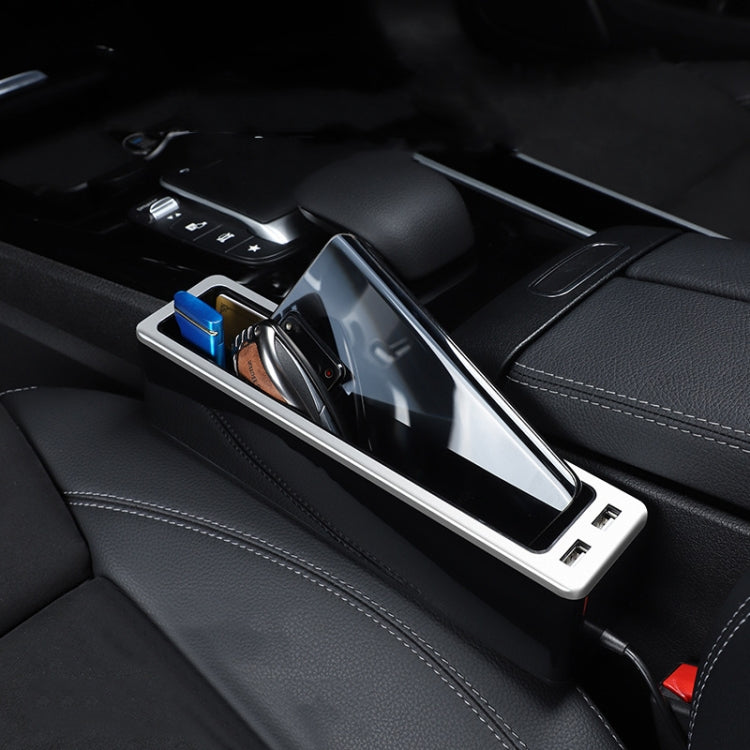 Car seat gap storage box with silver frame holding keys, phone, and accessories