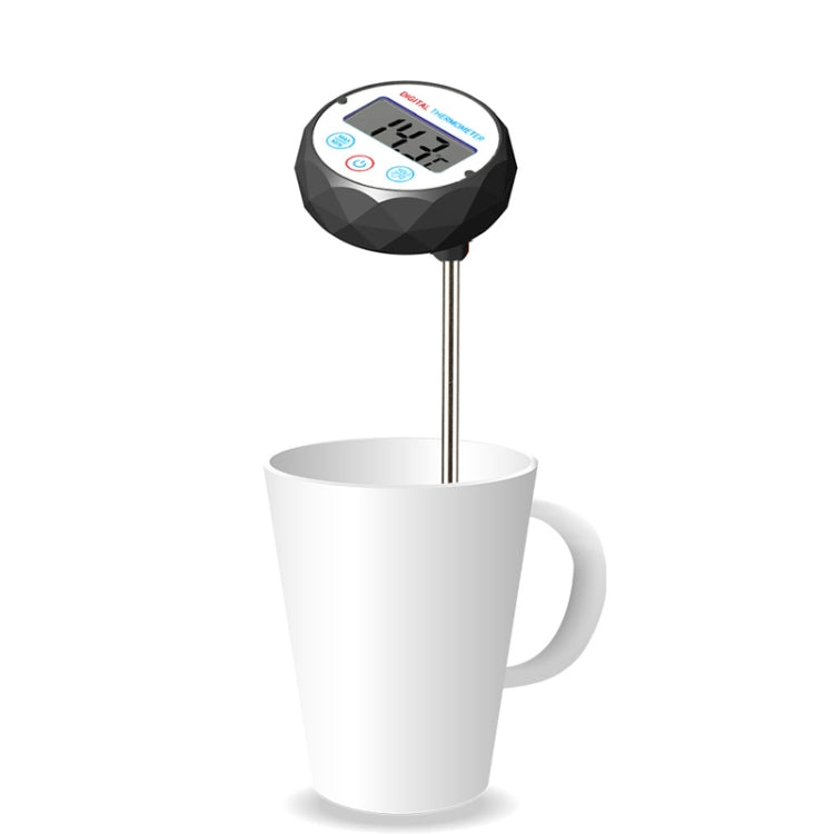 Digital food thermometer probe with LCD display standing in a white mug