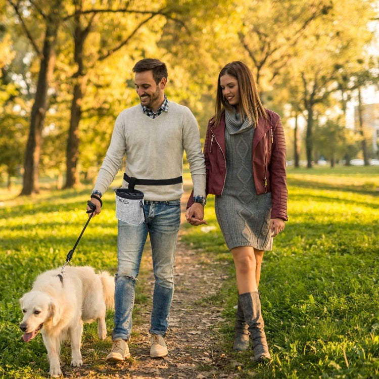 Dog snack bag clipped at waist during outdoor walk next to leashed pet