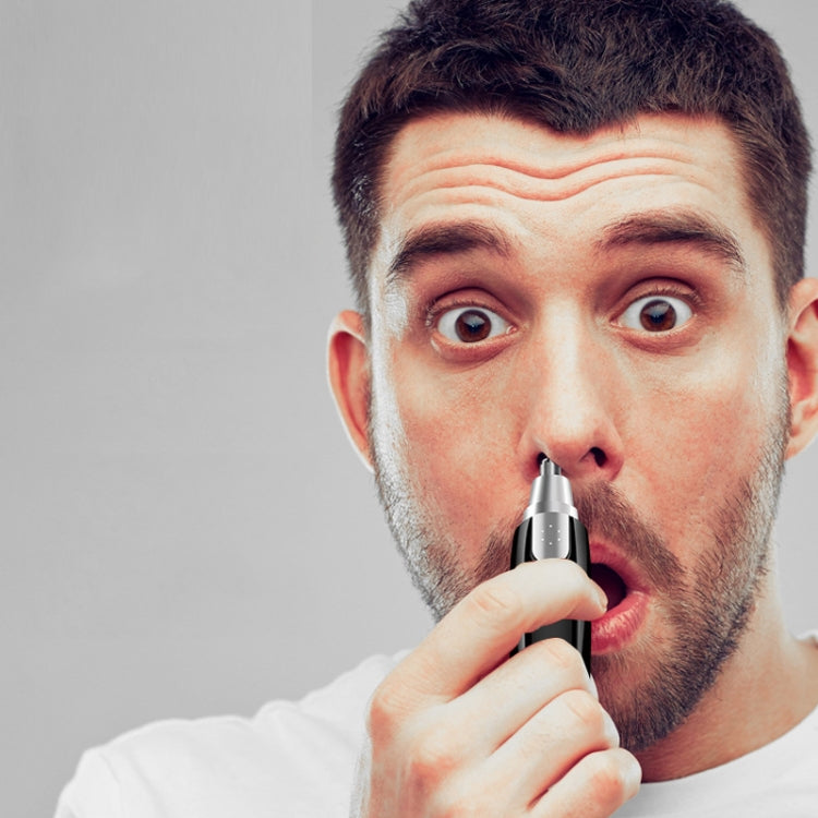Handheld nose hair trimmer in use, tip placed at nostril