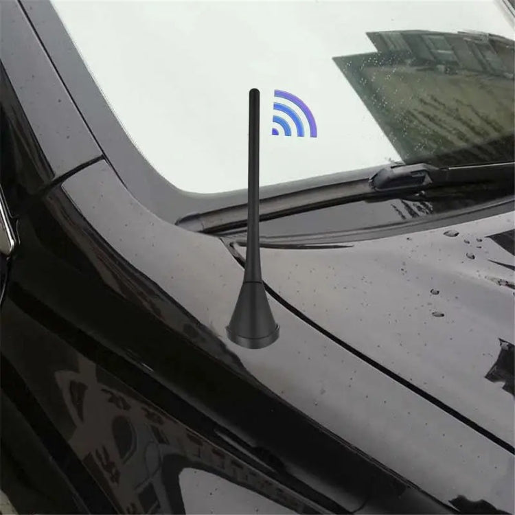 Black roof-mounted car antenna with mounted base on windshield area