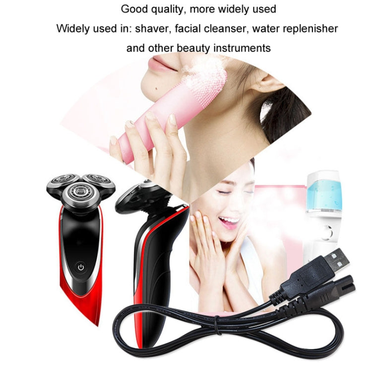 Black USB charging cable connected to a handheld electric shaver