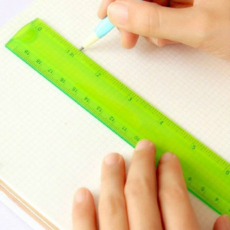 Lime-green flexible ruler held by hand on grid paper, showing measurement numbers