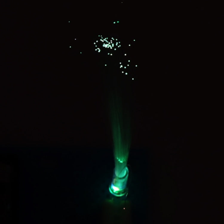 Lit fiber optic light with green glowing tip and sparkling fiber strands