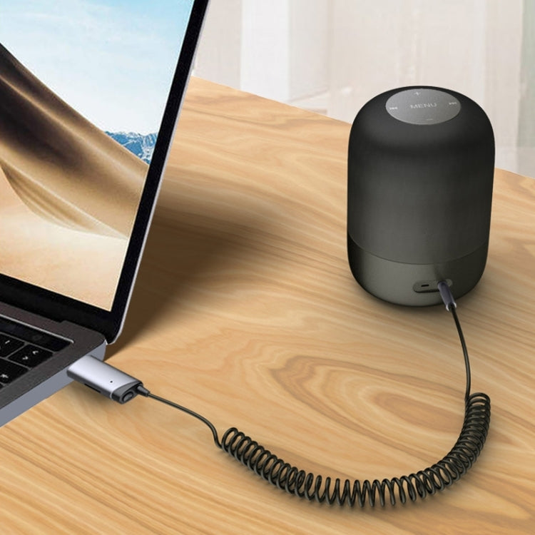 Bluetooth AUX receiver adapter with USB base and coiled cable on desk