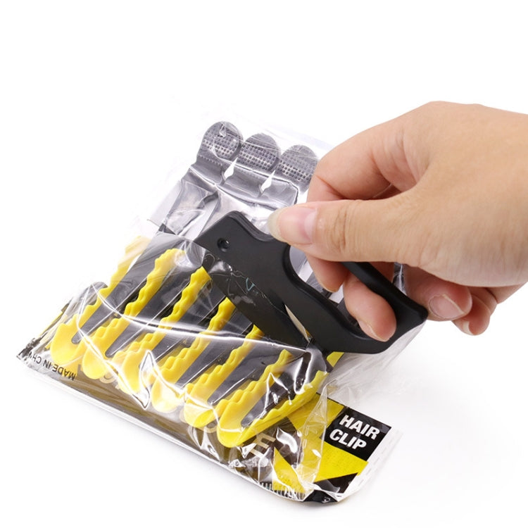 Black letter opener tool held above blister pack.