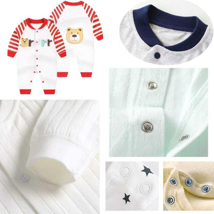 Clothing snap buttons with metal face plates on a light-colored bodysuit and cuffs