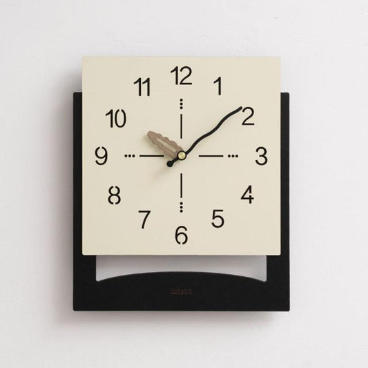 Cream white wall clock with minimalist black numbers and dark hanging base