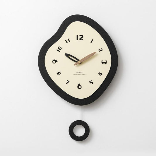 Irregular wall clock with black frame and cream dial, plus included mounting ring piece.