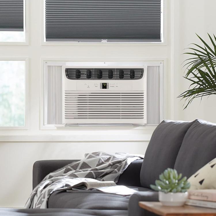 Installed window AC with white insulated side filler accordion panel