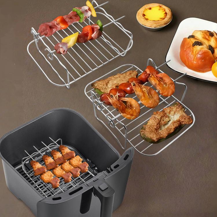 Air-fryer basket with grill rack holding grilled chicken and kebabs, with extra racks