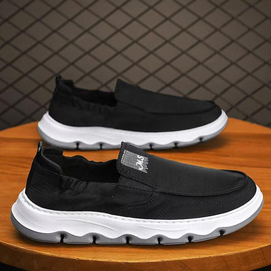 Mens slip-on canvas sneakers, black upper with white cushioned sole and pull tab