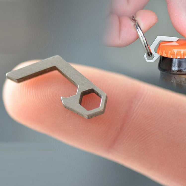 Mini bottle opener keyring tool, close-up gray metal bottle cap lifter