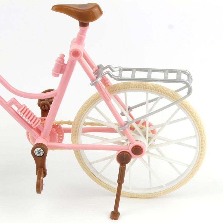 Close-up mini dollhouse bicycle wheel and frame: pink, tan rim, gray front rack