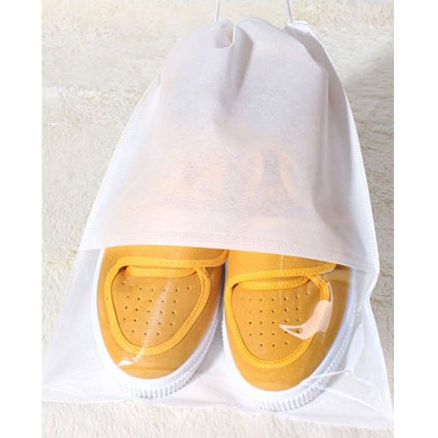White drawstring shoe bag holding yellow sneakers with clear front window