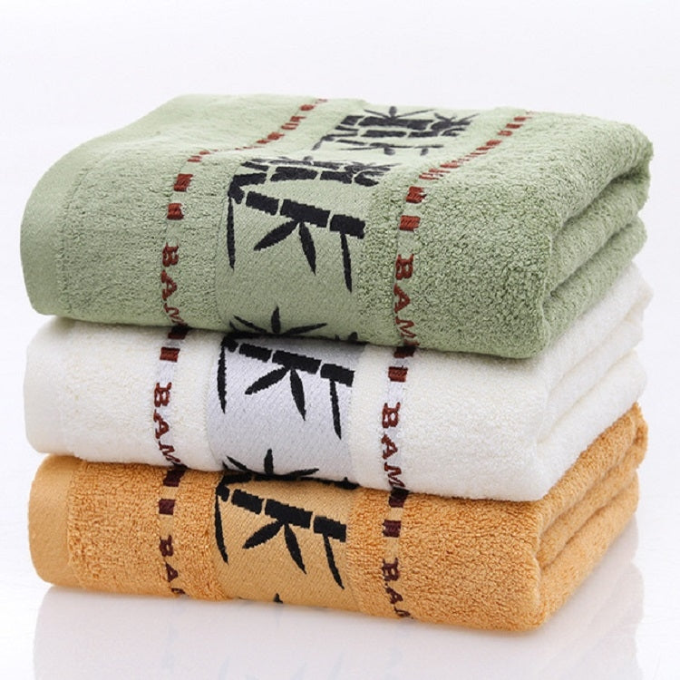 Stack of bamboo-print bath towels: green, white, and orange, folded in thirds