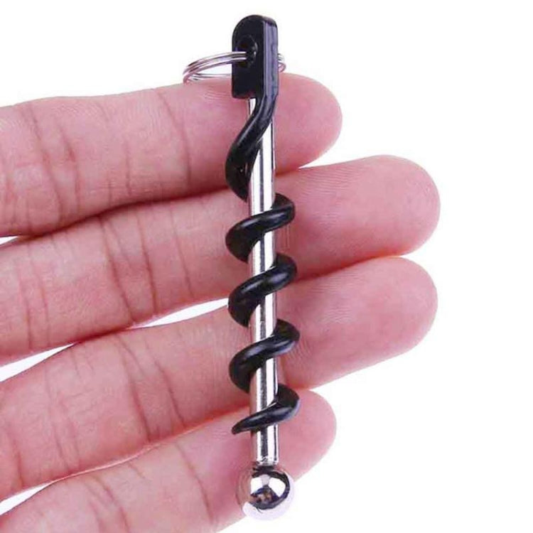 Corkscrew keychain tool held in hand, black spiral with chrome stem