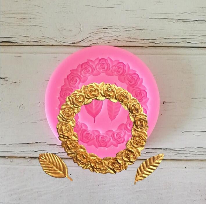Pink silicone mold with raised rose garland ring and leaf motifs
