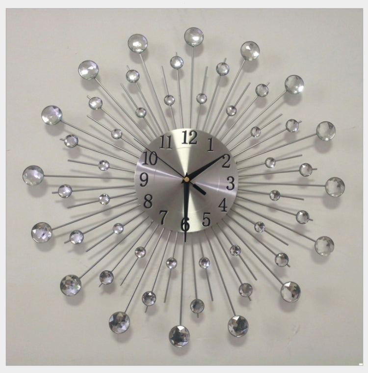Round sunburst wall clock with silver dial, crystal drops, and radiating metal spokes