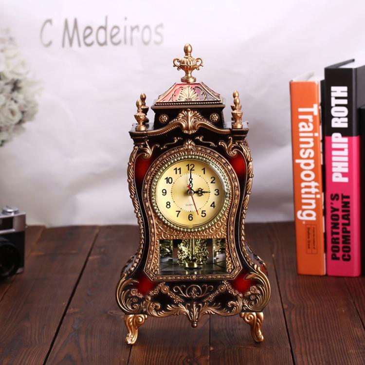 Decorative pendulum clock with dark body, gold frame, and cream dial with red hands