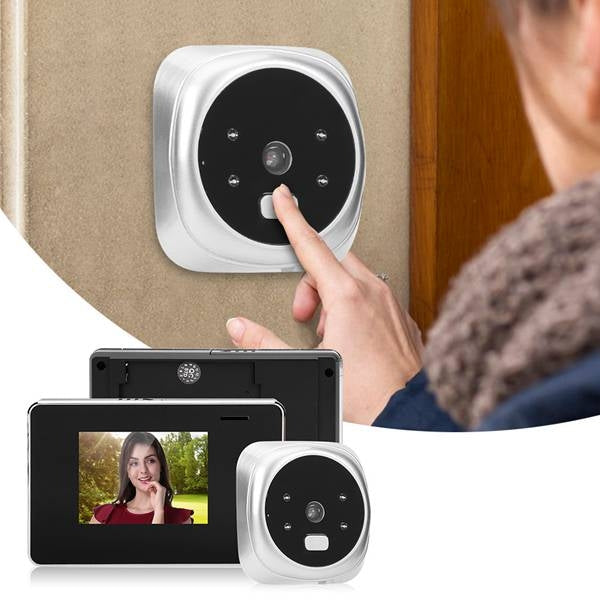 Hand pressing door peephole camera button next to black viewer and compact accessories