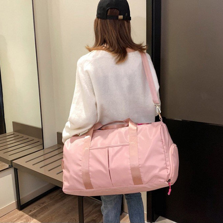 Pink nylon shoulder gym bag worn crossbody with adjustable strap