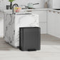 Black step-on trash can with lid and ribbed body, front pedal at base