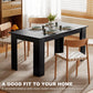 Black rectangular dining table with place settings and squared legs in a room