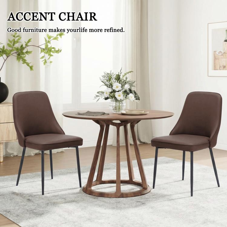 Two brown accent dining chairs with high backs and black metal legs around a round table