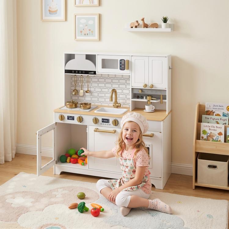 Kids play kitchen with open doors and kid playing beside it; gold faucet and stovetop