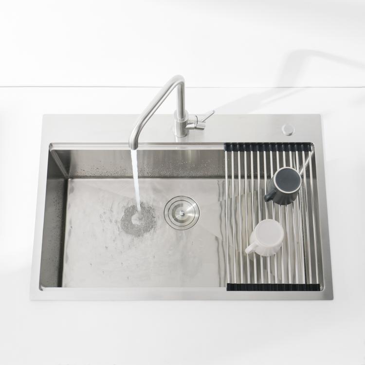Single-bowl stainless kitchen sink with dark gray basin, faucet, and colander rack