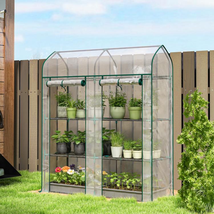 Clear 3-tier mini greenhouse with green frame and transparent panels, set outdoors