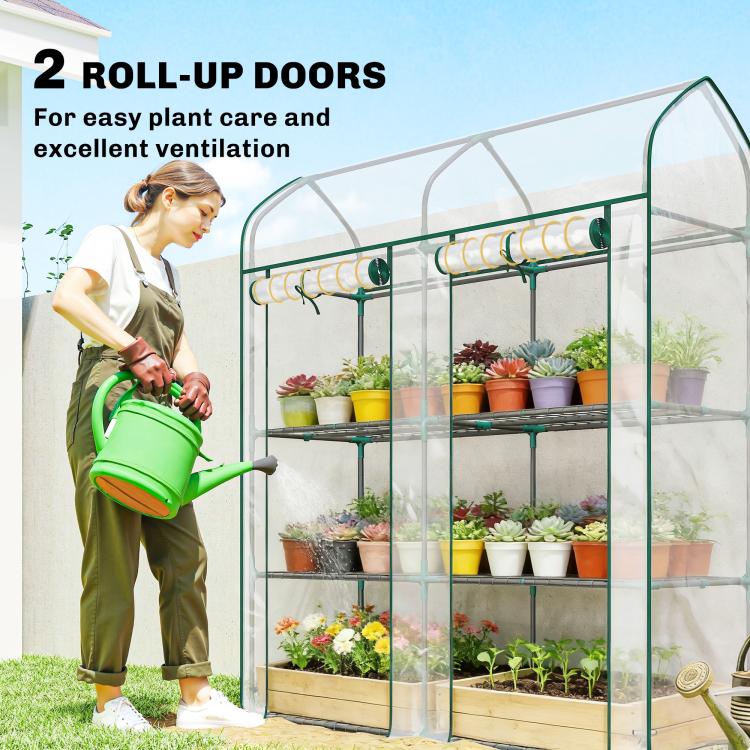 Clear mini greenhouse with green frame, two roll-up doors, and 3-tier wire shelves