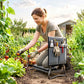Gray foldable garden kneeler with EVA pad and tool pouch in use by gardener.