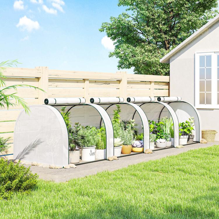 Portable tunnel greenhouse with white mesh cover and arched frame along a yard