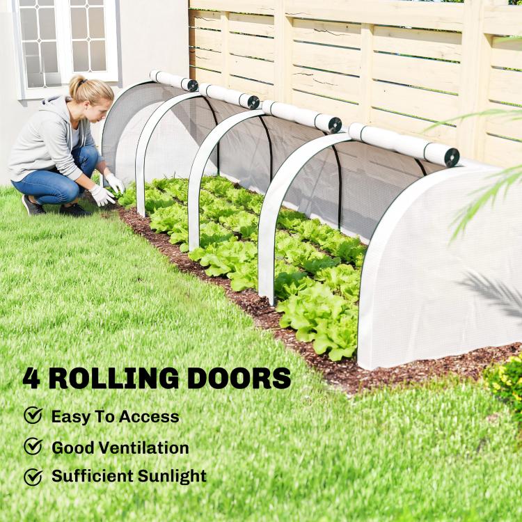 Portable tunnel greenhouse with white mesh cover and rolling doors over planted rows