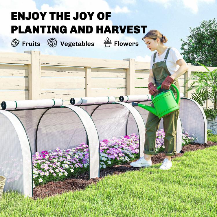 Portable tunnel greenhouse with white mesh panels and arched frame, person watering plants