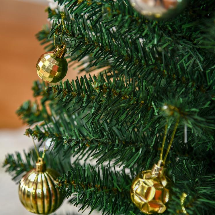 Green artificial pencil Christmas tree with gold baubles and dense needle branches