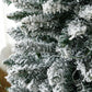 Snow-dusted slim artificial Christmas tree branches with realistic green needles