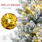 Snow-dusted artificial Christmas tree branches with warm white lit bulbs