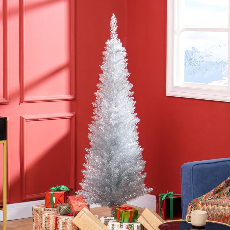 Silver unlit pencil artificial Christmas tree standing beside wrapped gifts