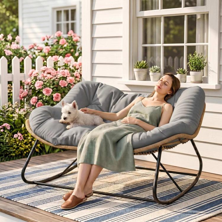 Gray papasan-style rocking chair with thick cushion and tan wicker base on patio
